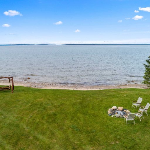 Stone fire pit and lawn swing on the shared lakefront lawn