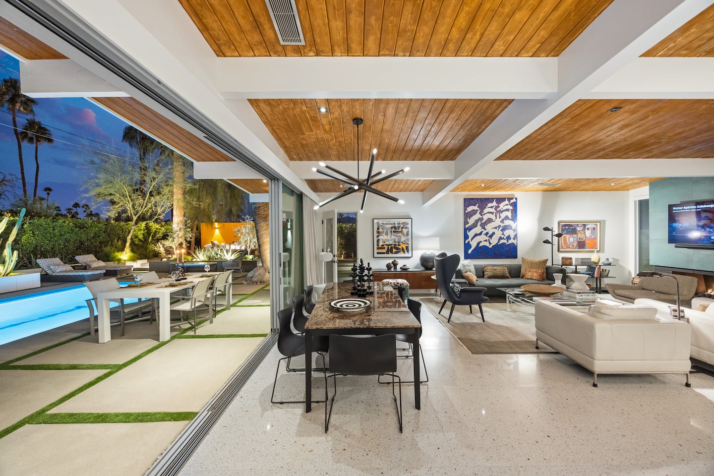 Open living room with vaulted wood ceiling and pool views