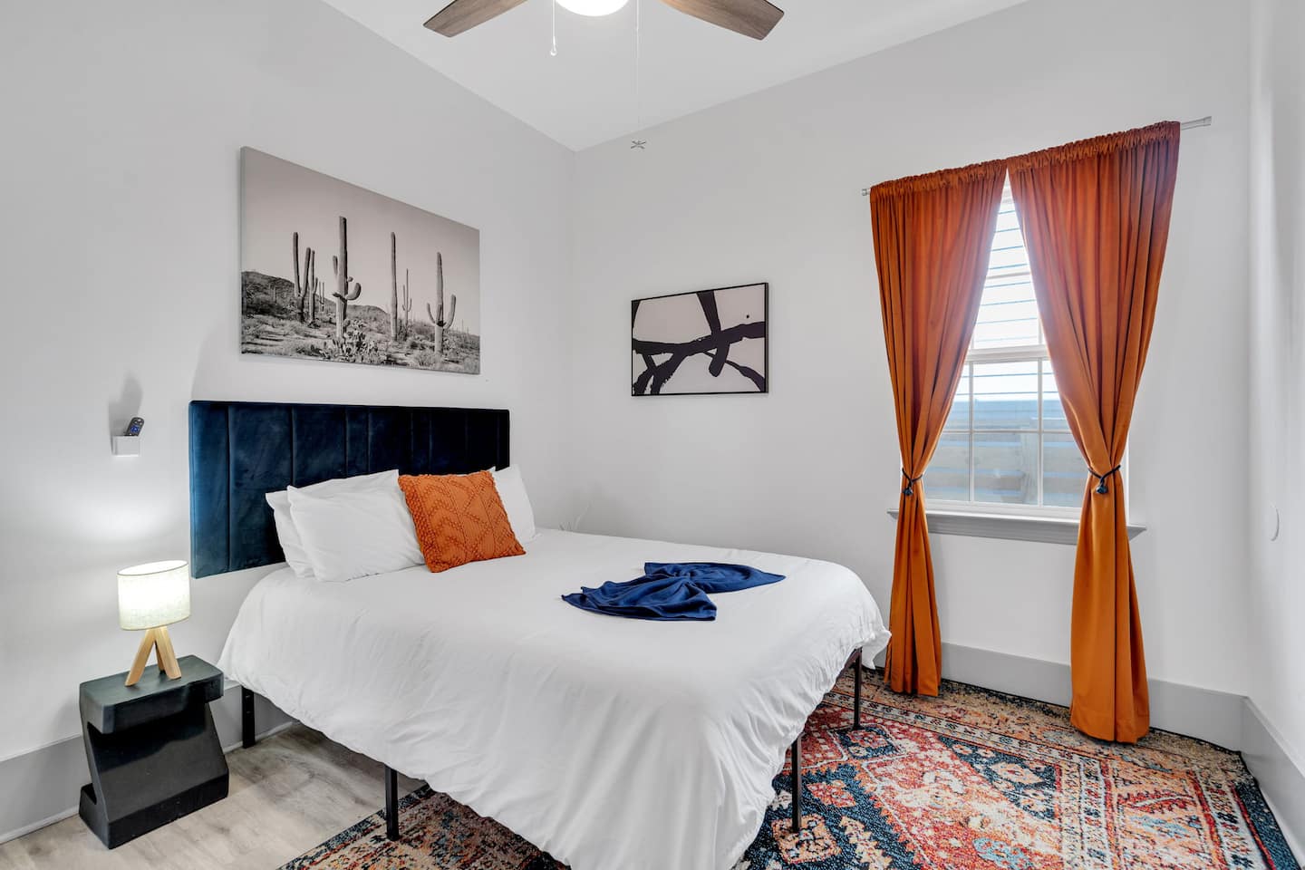 A cozy and stylish bedroom with a modern design, featuring a plush headboard, soft linens, and warm desert-inspired decor.