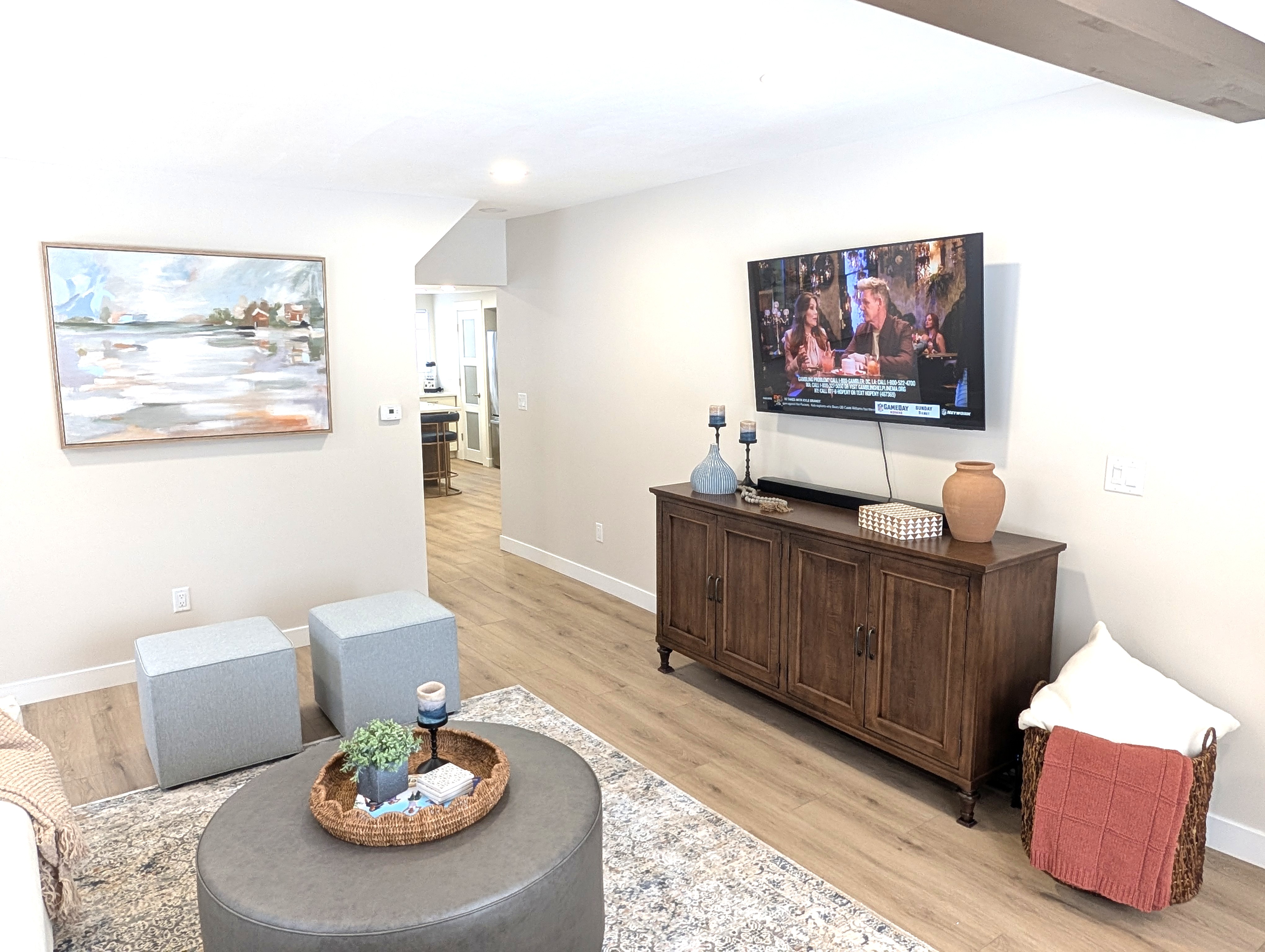 LIVING ROOM:  The home has a gorgeous newly-decorated living room with a sofa, comfy chairs, ottoman, and large screen television