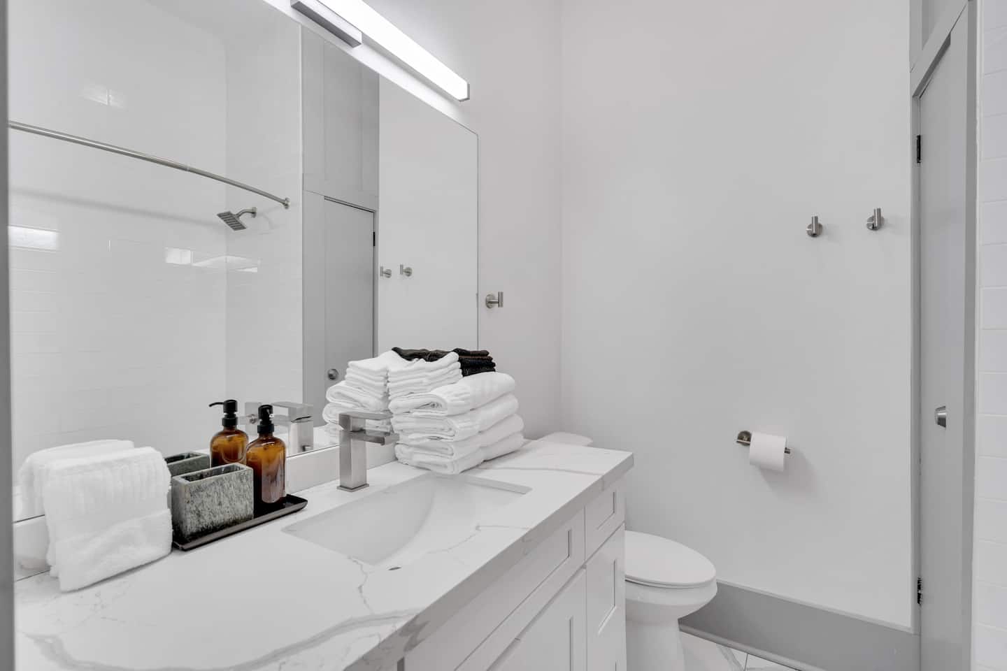Enjoy a modern, spa-like bathroom with a marble vanity, rain shower, and fresh towels ready for you. Clean, bright, and fully stocked for a refreshing stay!
