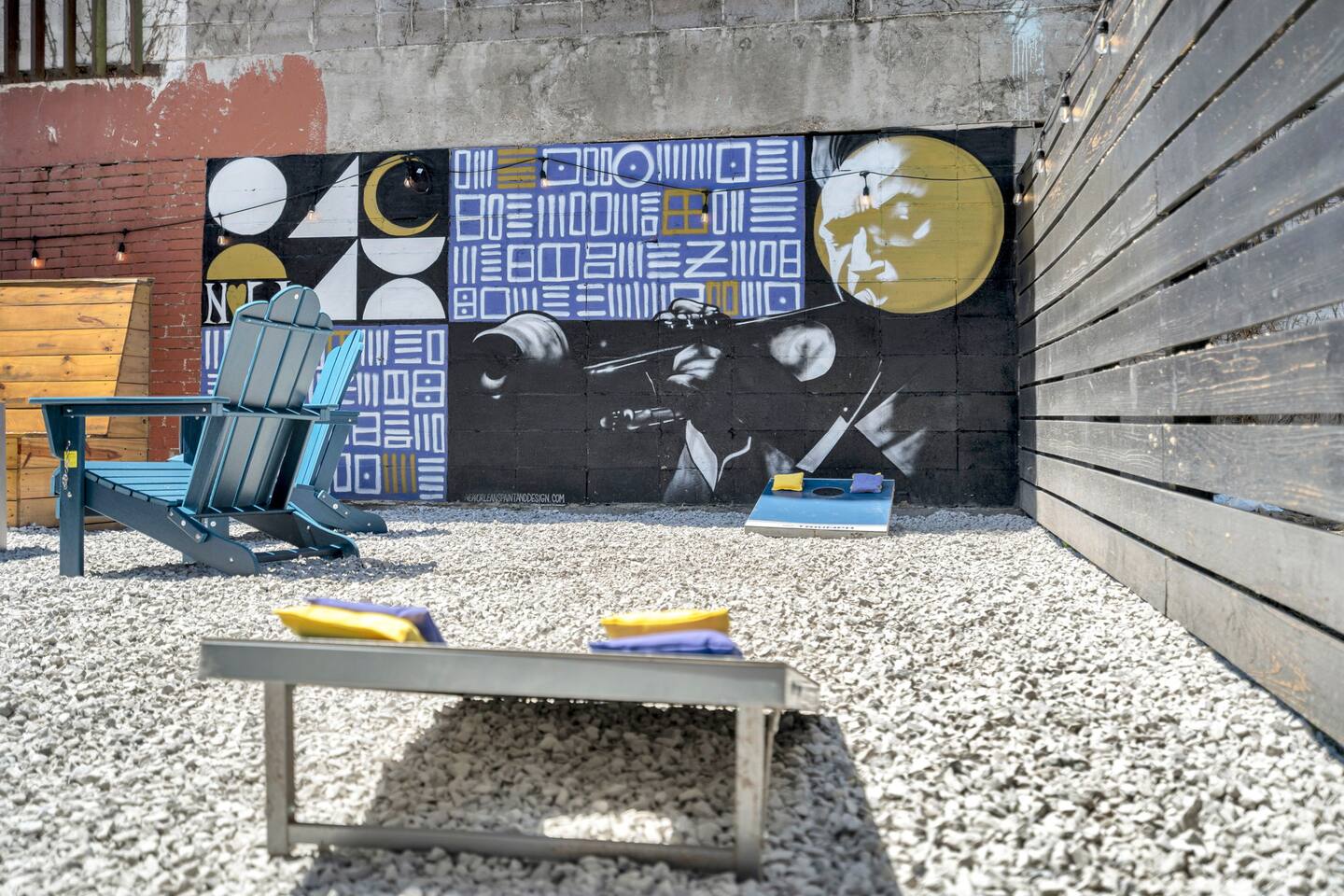 Game on with local art vibes—backyard cornhole and cool NOLA flair.