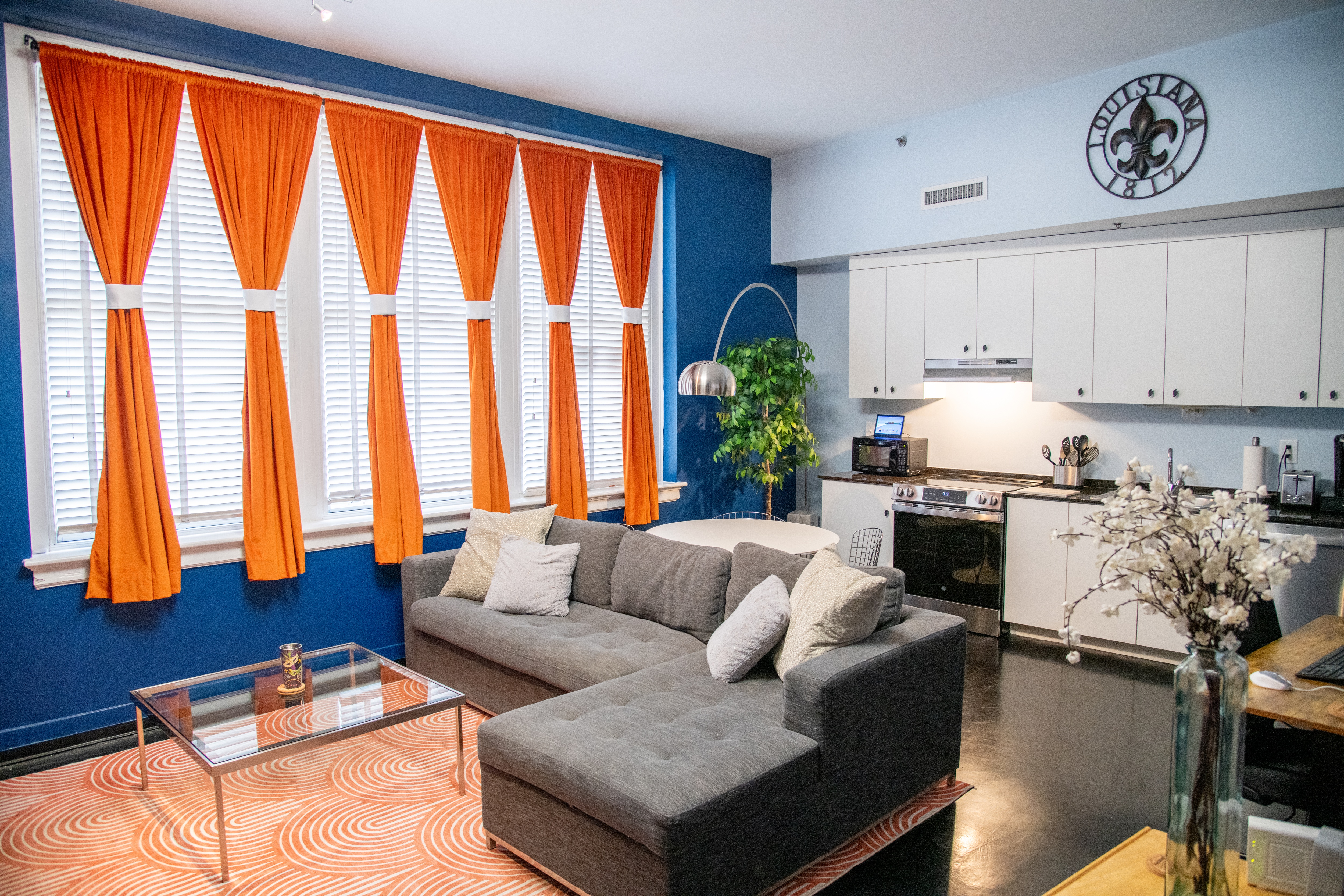 Chic and cozy—this bright living room is the perfect spot to relax, featuring modern furnishings and a splash of New Orleans flair.