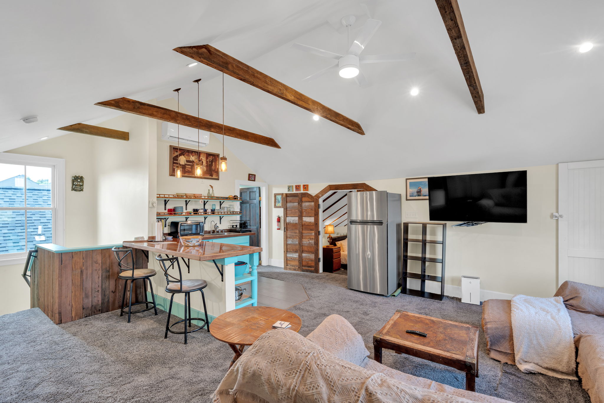 Bright open-concept living area with exposed beams and vintage charm.