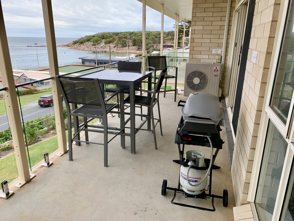 Spacious Balcony. Bar-height outdoor dining with 4 chairs. Glass balustrades for enhanced ocean vistas. Equipped with a brand-new Baby Weber Q BBQ with hood.