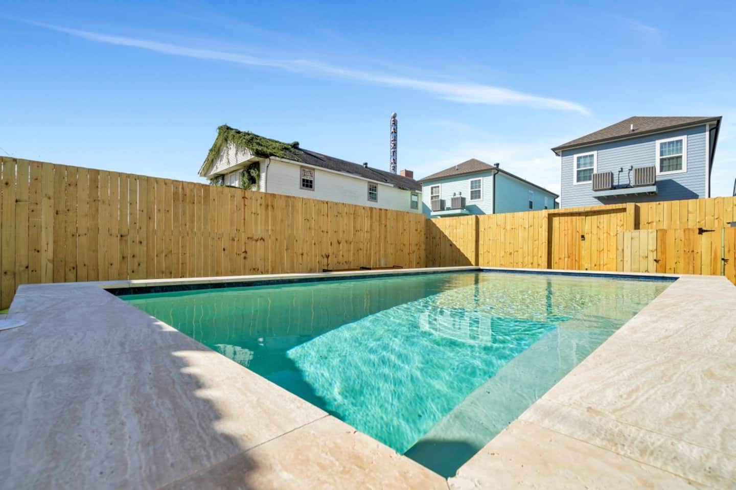 Fully-Fenced Pool with pool toys, towels, and lounge chairs