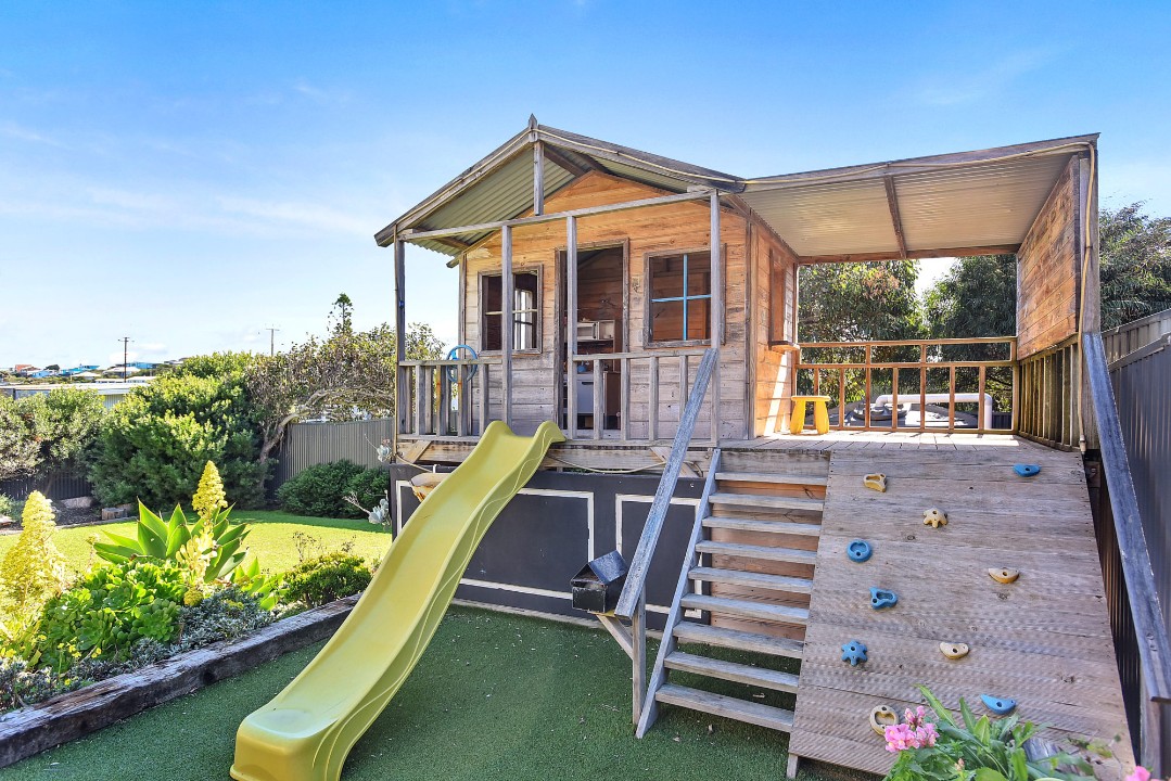 Outdoor shower, cubby house with slippery slide, grassy yard for play, and secure parking.