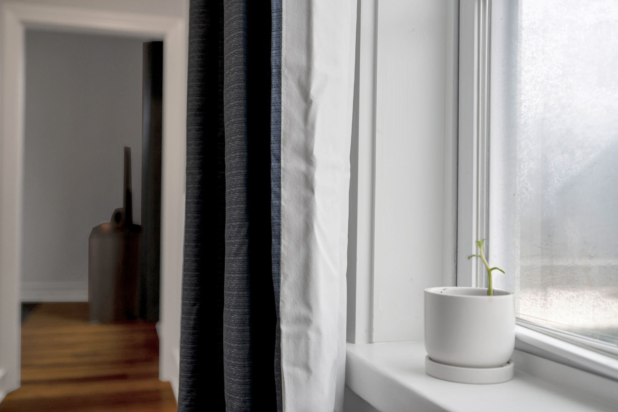 Simple windowsill with blackout curtains and natural light.
