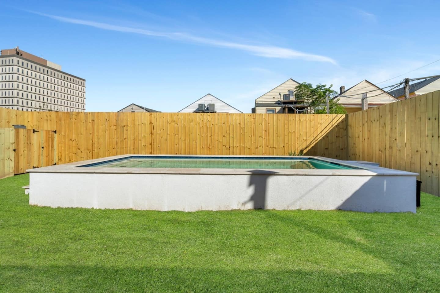 Fully-Fenced Pool with pool toys, towels, and lounge chairs
