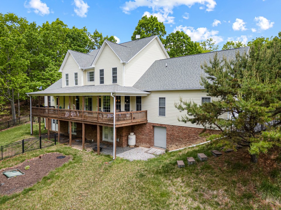 Backyard view of the home with an elevated porch and plenty of space ...