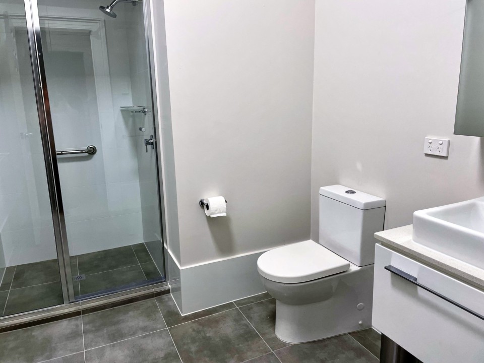 Open plan lounge, dining, and kitchen areas with smart TV, free WiFi, split system air conditioning, modern kitchens, and refurbished bathrooms in each unit featuring contemporary fixtures for guest comfort.