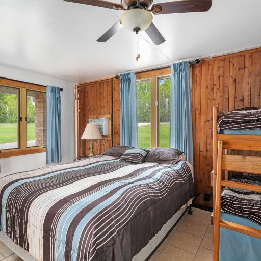 Main bedroom features queen bed plus twin bunks — ideal for small families or couples