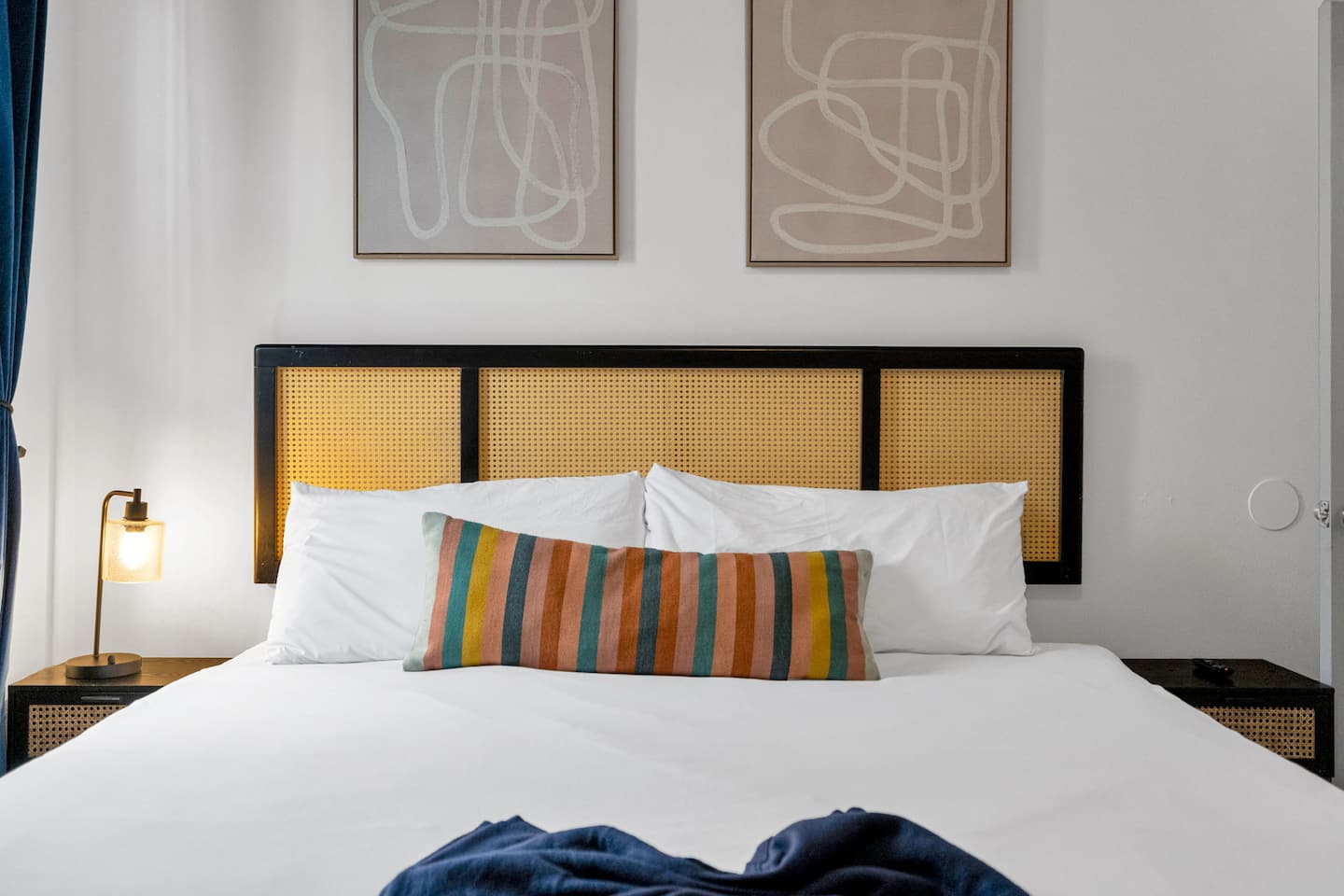 A closer look at luxury! This inviting bedroom showcases a stunning tufted leather headboard, modern wall sconces, and chic abstract artwork—designed for both style and relaxation.
