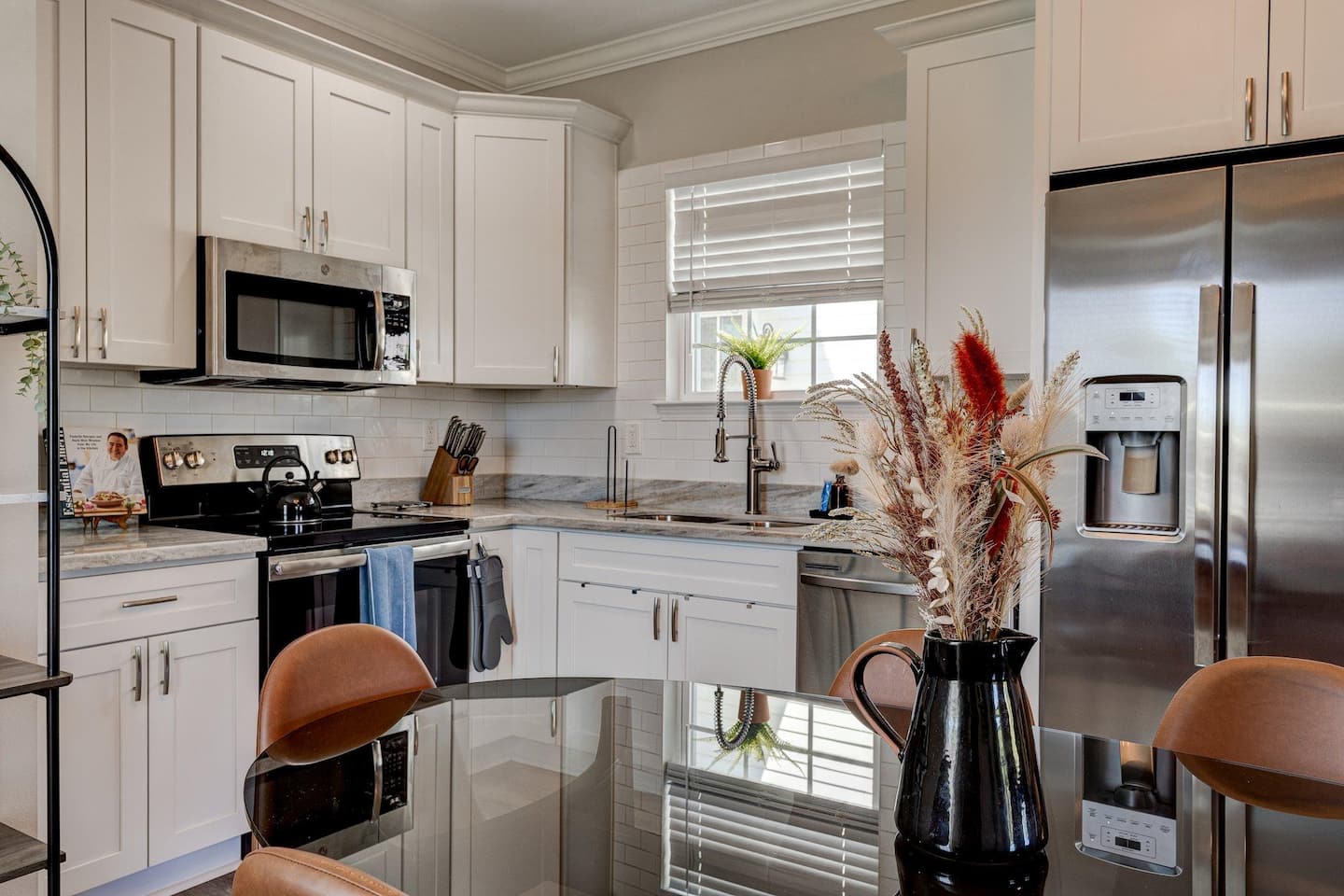Modern kitchen featuring stainless steel appliances, spacious countertops, and a cozy dining area that comfortably seats six – perfect for enjoying meals or entertaining.