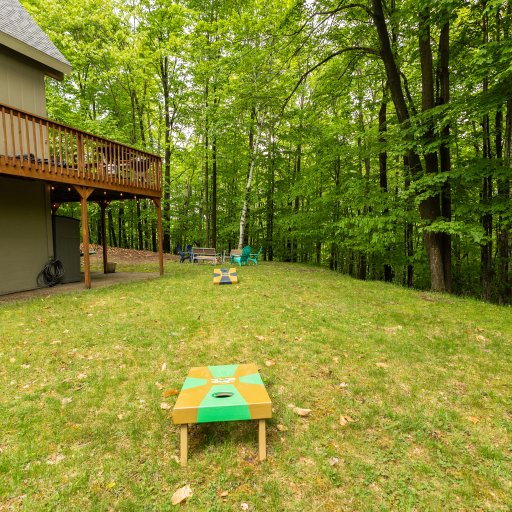 The spacious backyard offers room for lawn games, including cornhole—perfect for family fun and outdoor activities