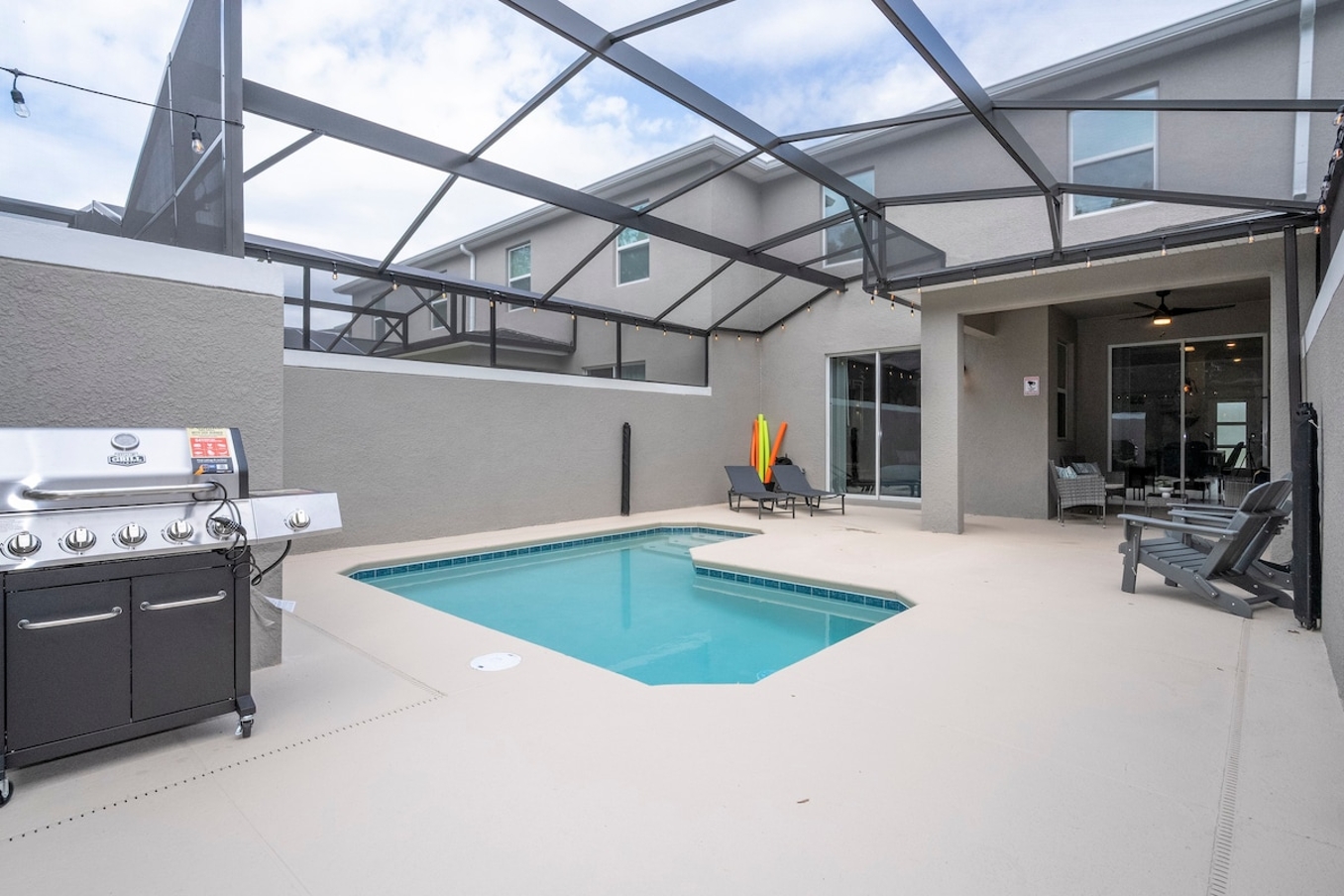 A spacious, comfortable, and family-friendly outdoor space that is perfect for guests looking for the perfect vacation home. The area is designed to meet every need of a guest, from grilling on the state-of-the-art BBQ under the expansive screened patio to taking a refreshing dip in the pristine pool. The cozy seating area is perfect for relaxing with loved ones, and the sliding glass doors provide easy access to the indoor living space. Every corner of this area exudes warmth and hospitality, ensuring your stay is nothing short of extraordinary.





A spacious and inviting pool area, perfect for guests seeking that extra touch of luxury. The expansive pool, illuminated by the gentle glow of elegant lighting, offers a serene escape where you can unwind after a day of exploration. The cozy loungers provide the perfect spot to soak up the tranquil atmosphere, with every detail designed to make your stay an unforgettable experience. The screened structure keeps the area bug-free and comfortable, while warm lighting adds to the ambiance, creating a cozy and welcoming atmosphere. Direct access to indoor living spaces through sliding glass doors makes it easy to transition from indoor to outdoor living. This is the perfect place to relax and enjoy your vacation.