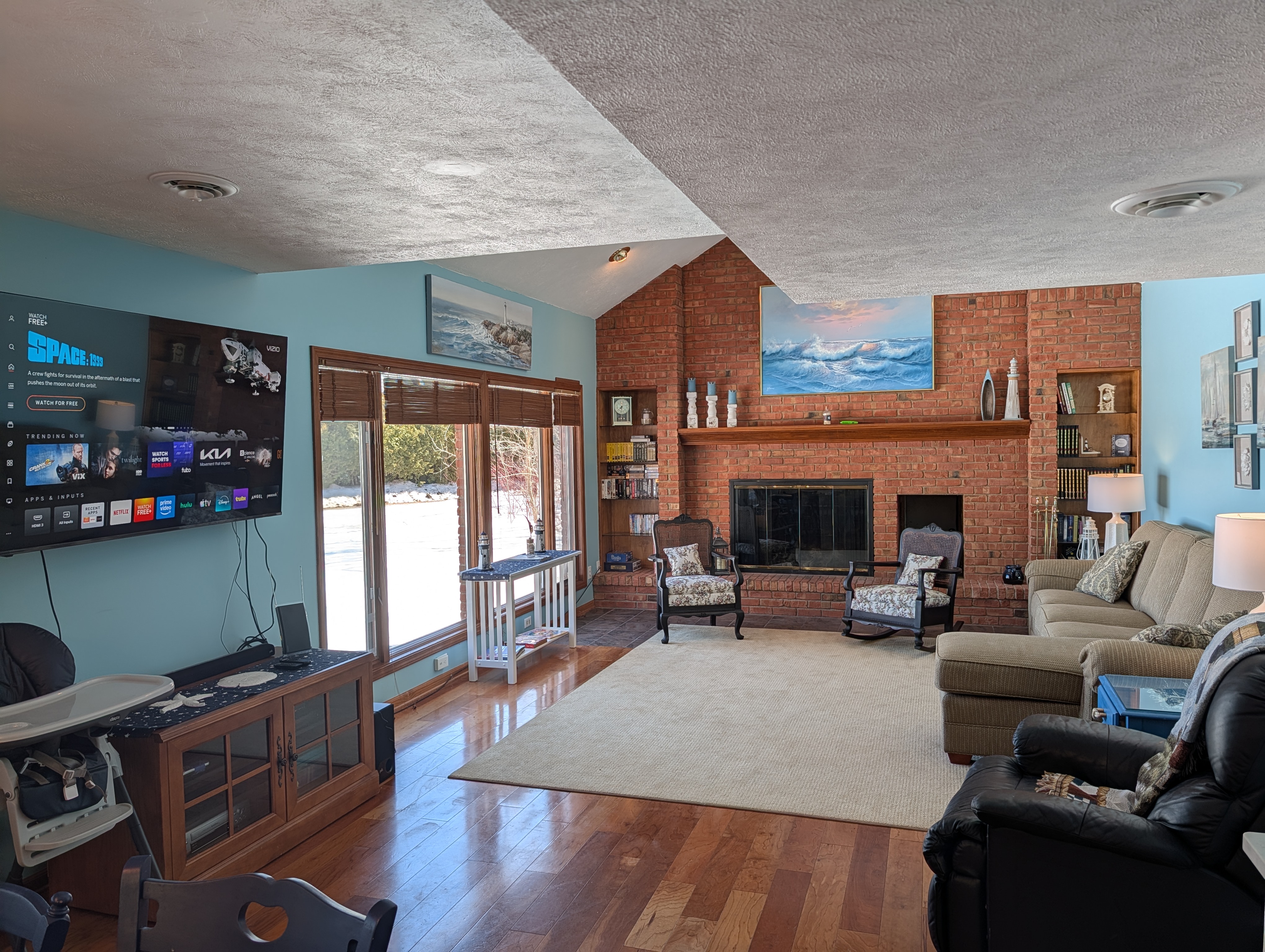 LIVING ROOM #1:  The primary living room, which has a great view of Big Platte Lake!  (Note that the wood fireplace in the photo is available for guest usage.)