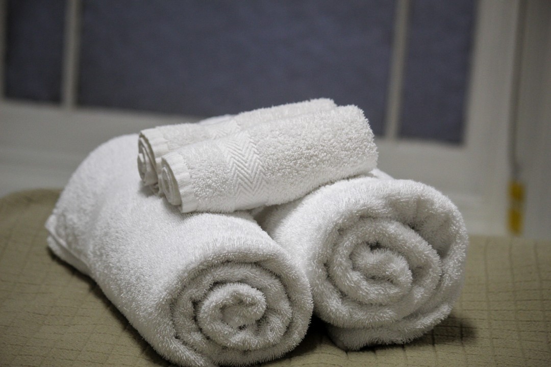 Full linen and towels are included in every stay, complemented by access to a shared coin-operated washer, dryer, and ironing facilities.