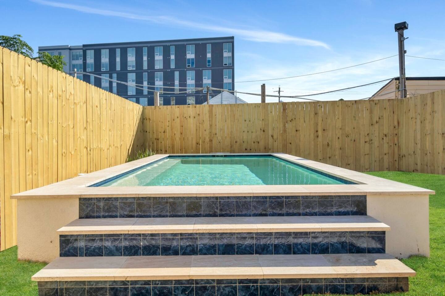 Fully-Fenced Pool with pool toys, towels, and lounge chairs