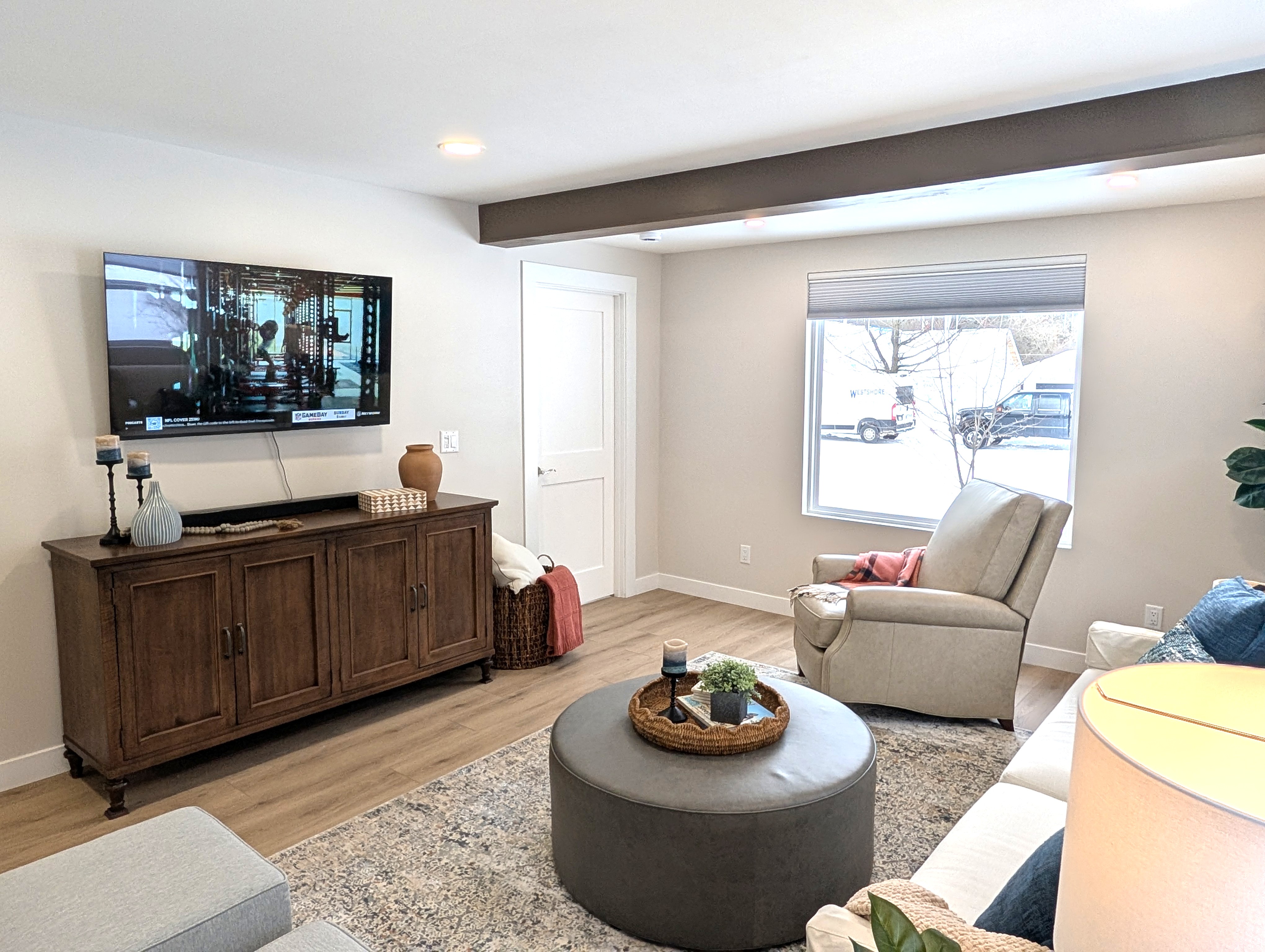 LIVING ROOM:  The home has a gorgeous newly-decorated living room with a sofa, comfy chairs, ottoman, and large screen television