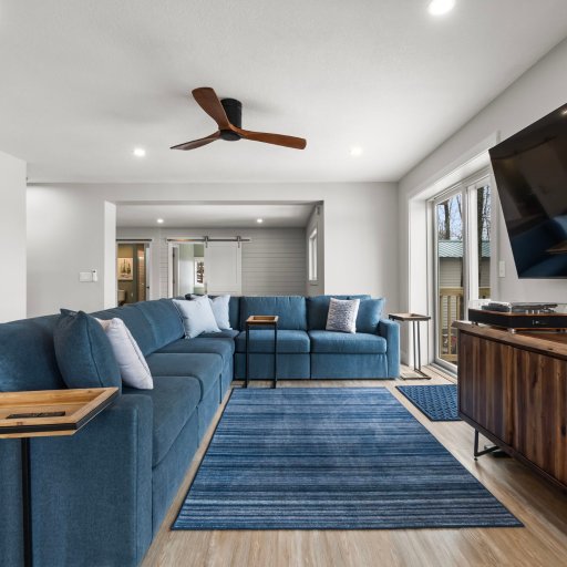 Living room with large sectional, 65-inch smart TV, and vinyl turntable