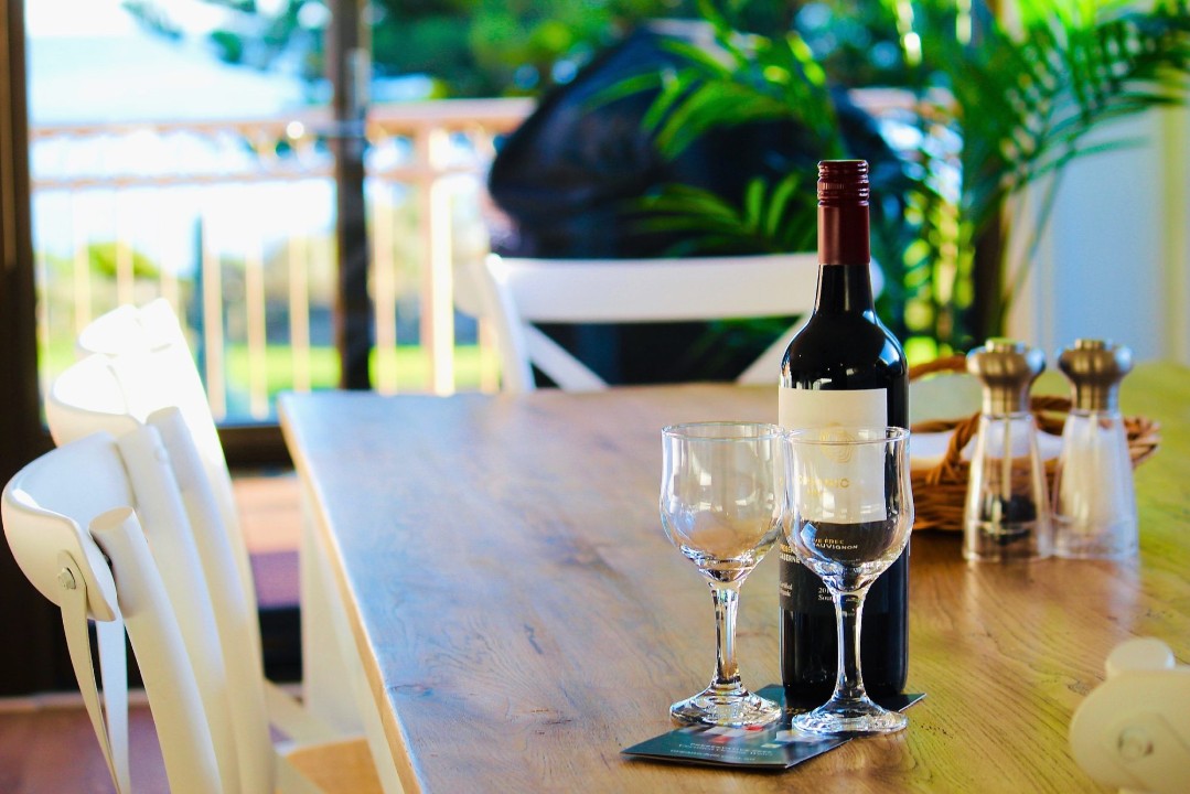 Wake up to stunning views of Victor Harbor’s coastline right from your balcony. (Wine pictured is for styling purposes only.)