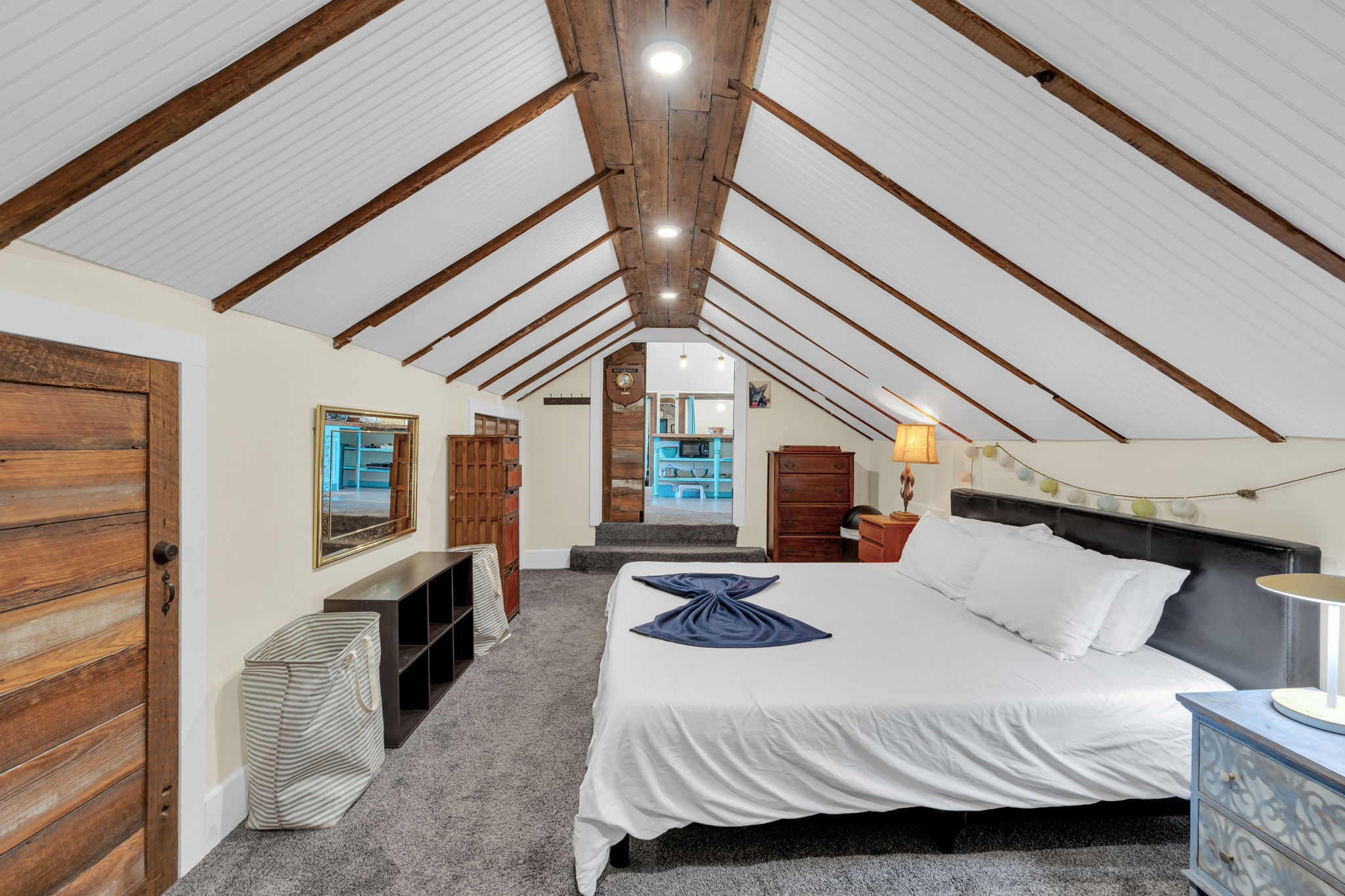 Bedroom-4: Spacious loft with exposed beams and inviting comfort.