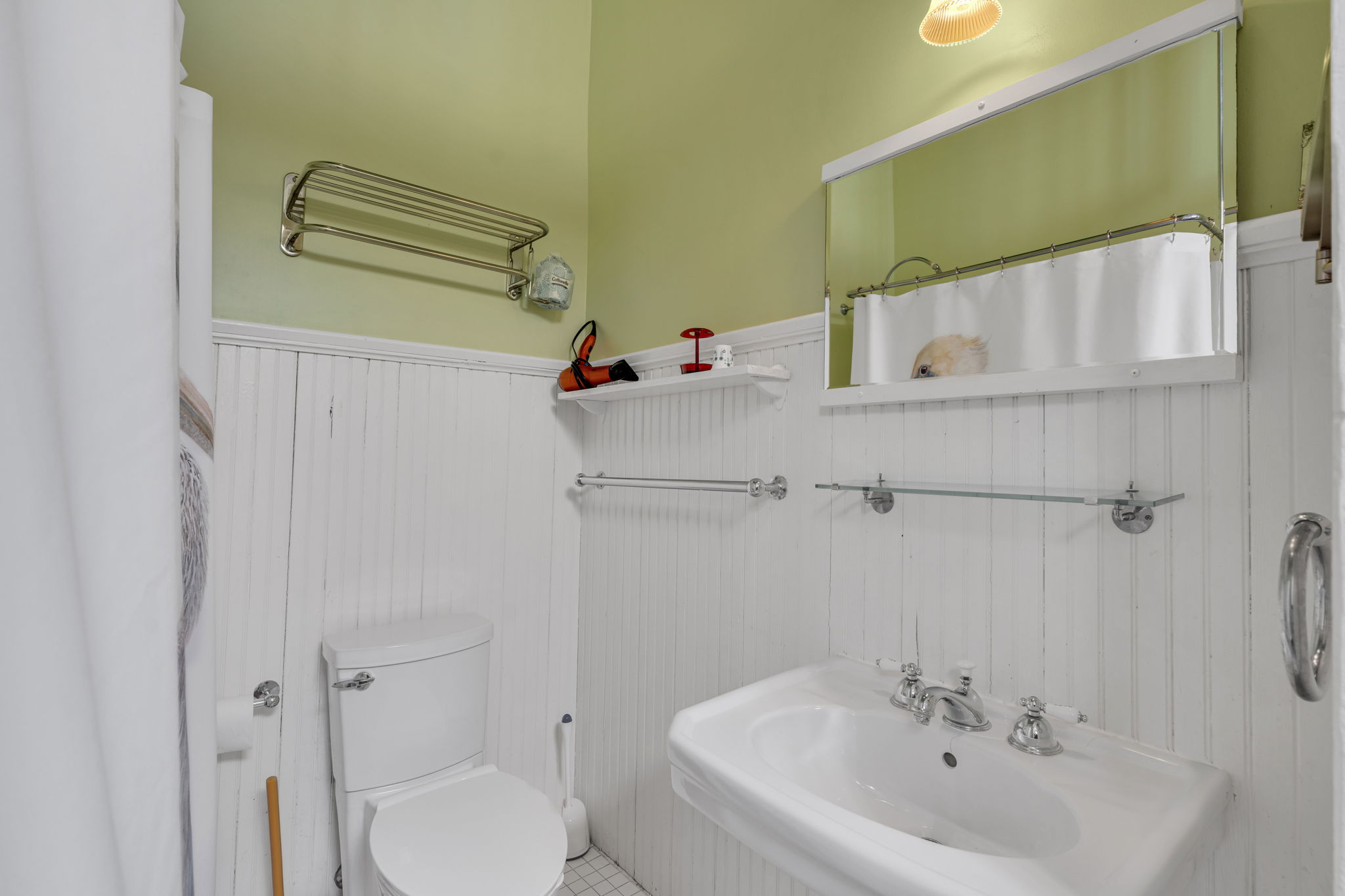 Charming vintage bath featuring a classic clawfoot tub, white beadboard, and a clean design.