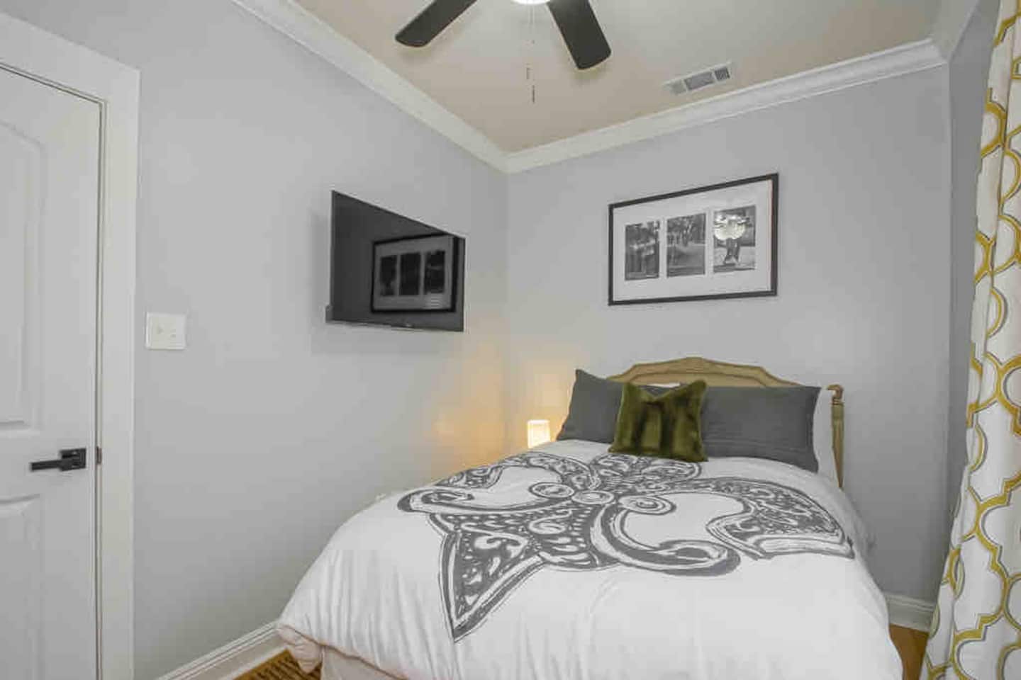 First Bedroom honoring the Fleur De Lis NOLA theme with smart tv, luggage rack, closet organization