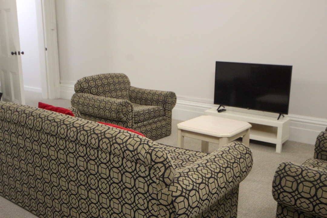 Communal laundry facilities with washing machine, dryer, and ironing equipment.
