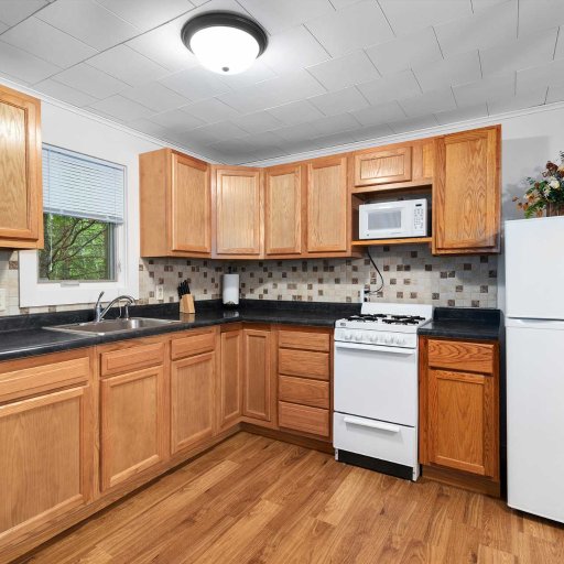 Full kitchen — gas range, microwave, full-size fridge, and drip coffee maker