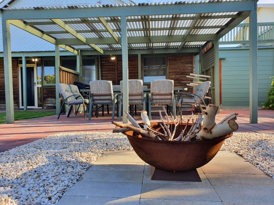 Backyard includes a pergola, BBQ area, and fire pit for laid-back evenings.