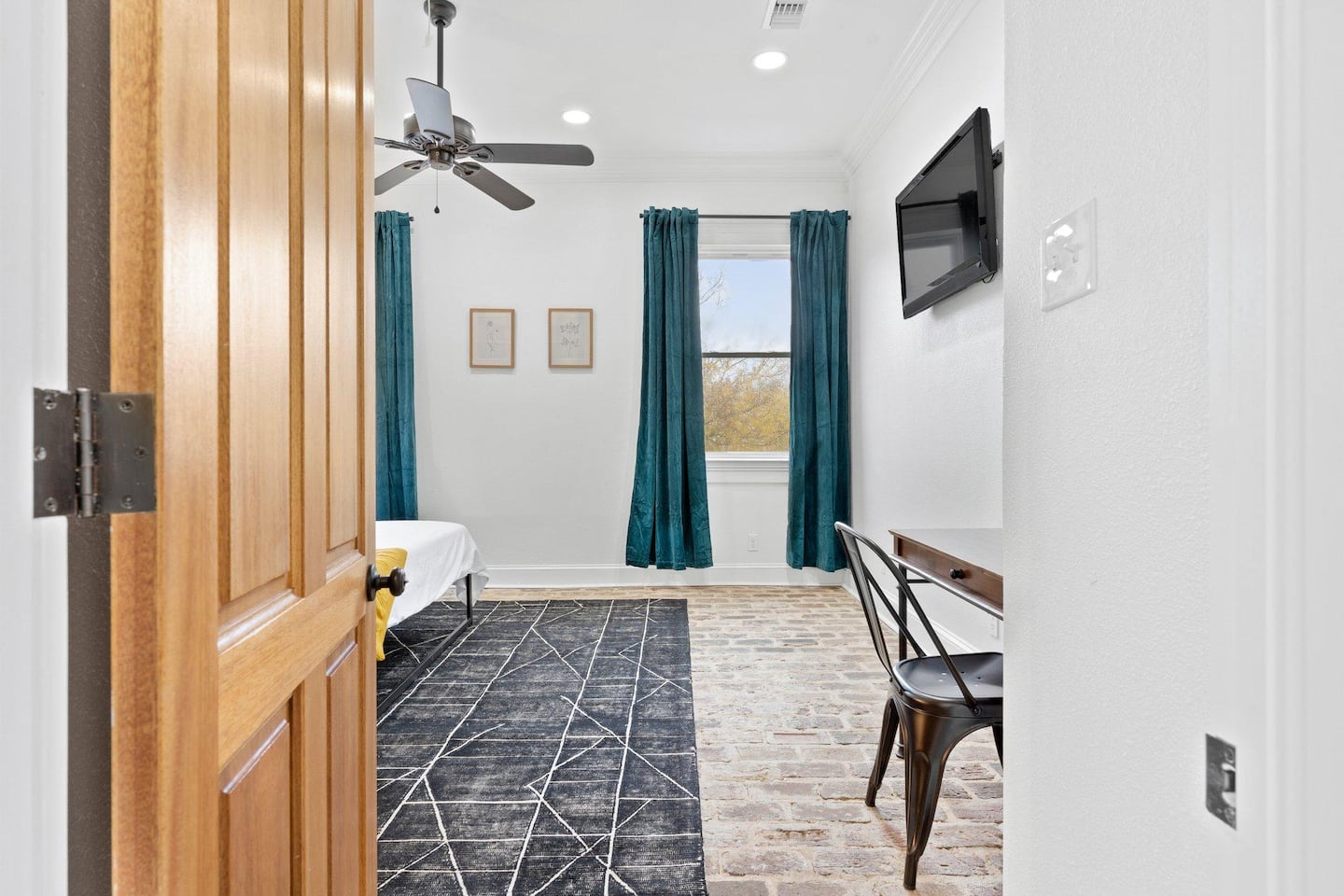 View walking into bedroom 1 (brick floors!) from the living room