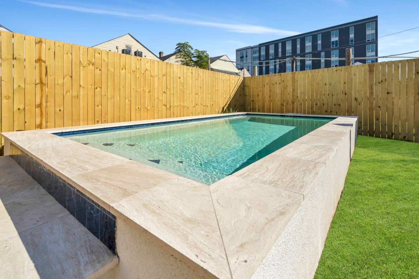 Fully-Fenced Pool with pool toys, towels, and lounge chairs