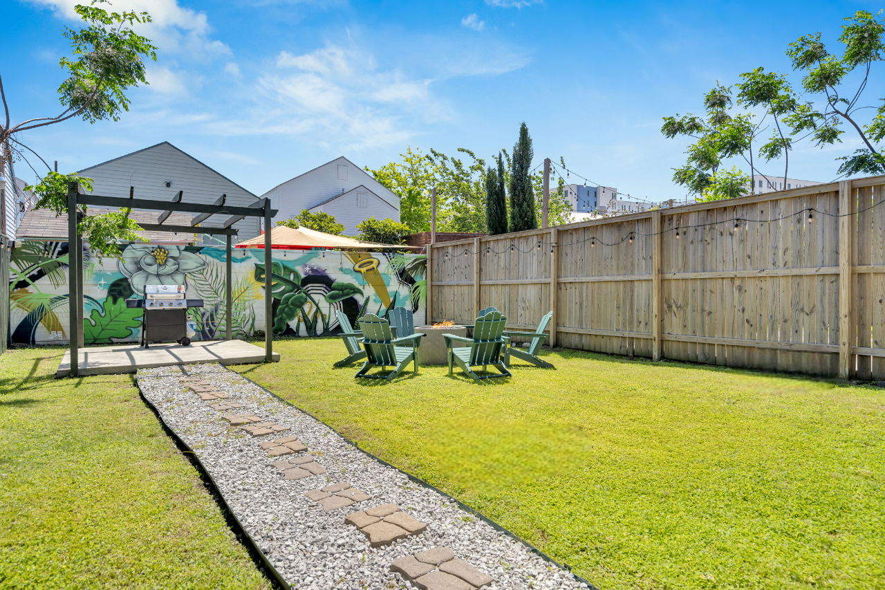 Spacious yard with a fire pit and a local art backdrop.