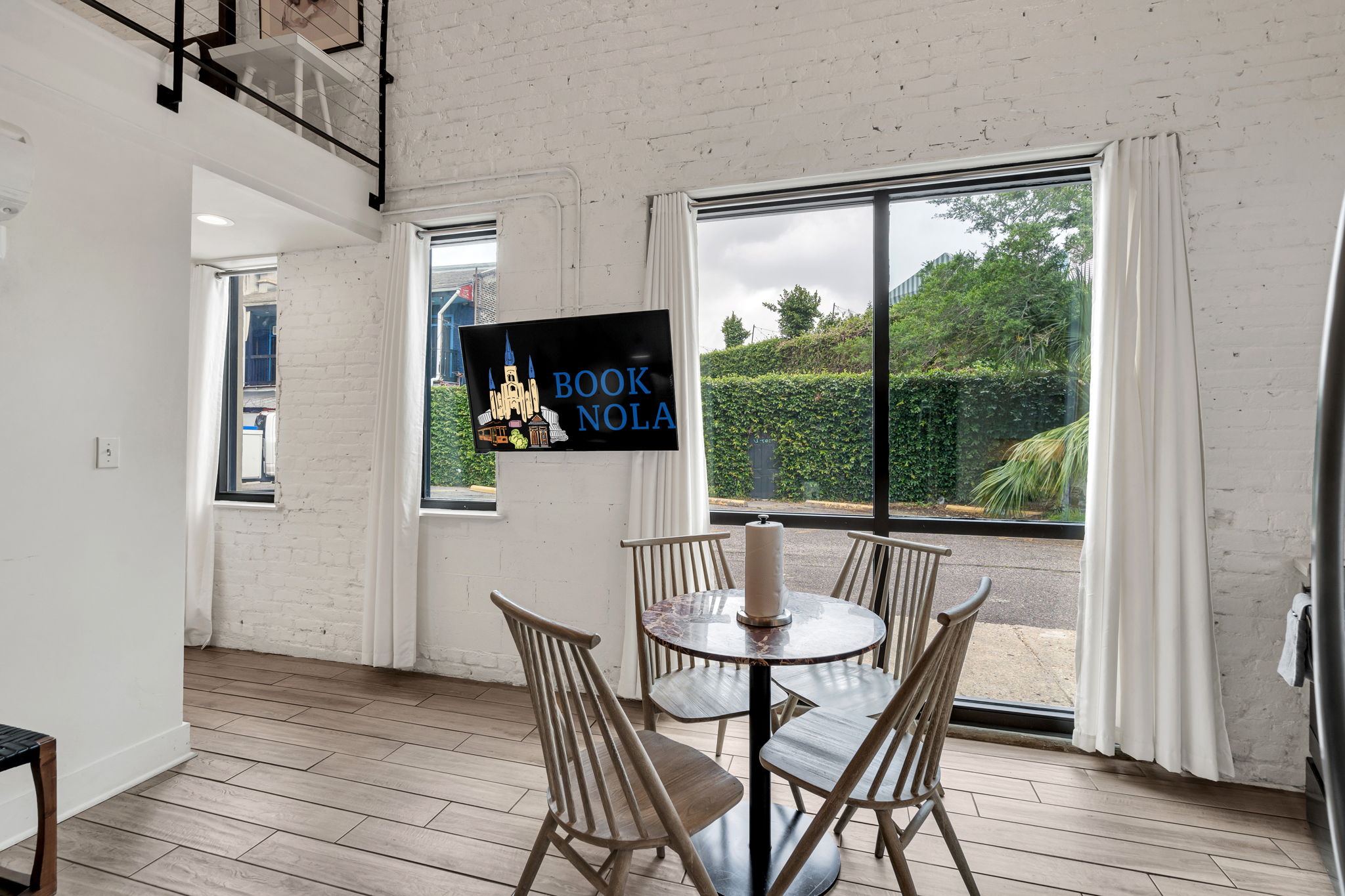 Charm meets natural radiance as the living room’s expansive windows invite the essence of New Orleans right inside (unit 2)