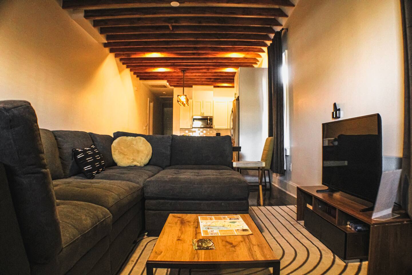 Relax in style with exposed beams, cozy seating, and a smart TV setup.