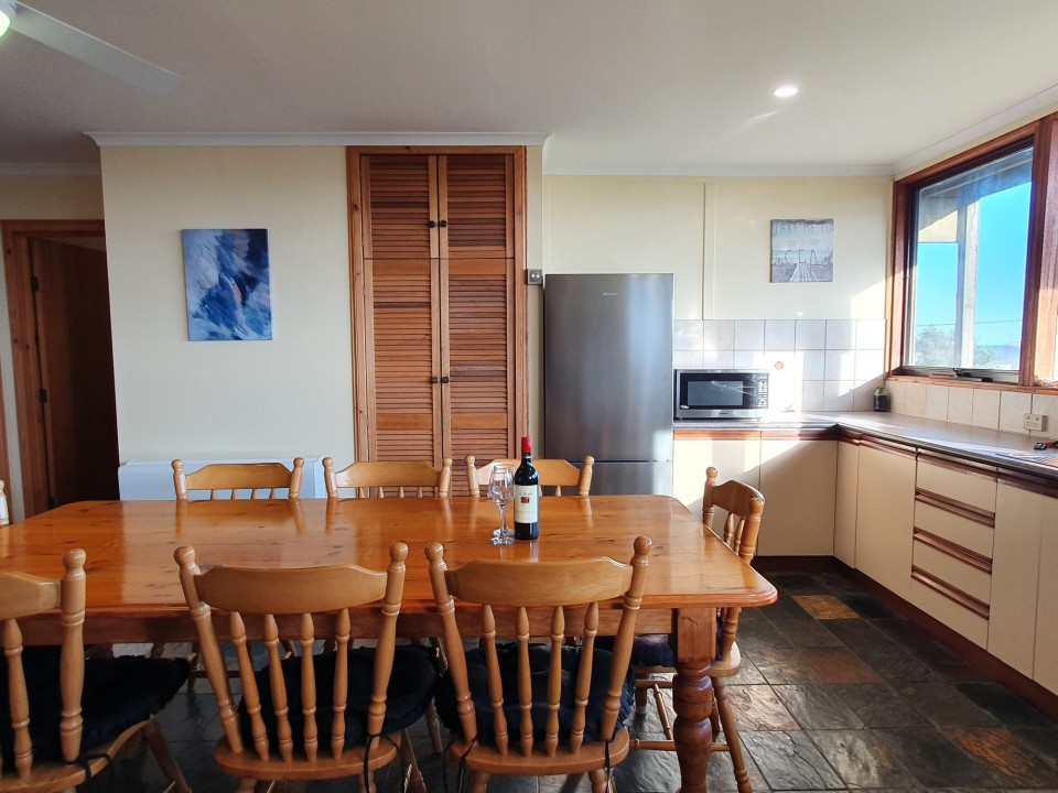 Lower level with bedrooms and dining; upper-level second lounge with a 7-seater couch and deck access—ideal for families or groups.