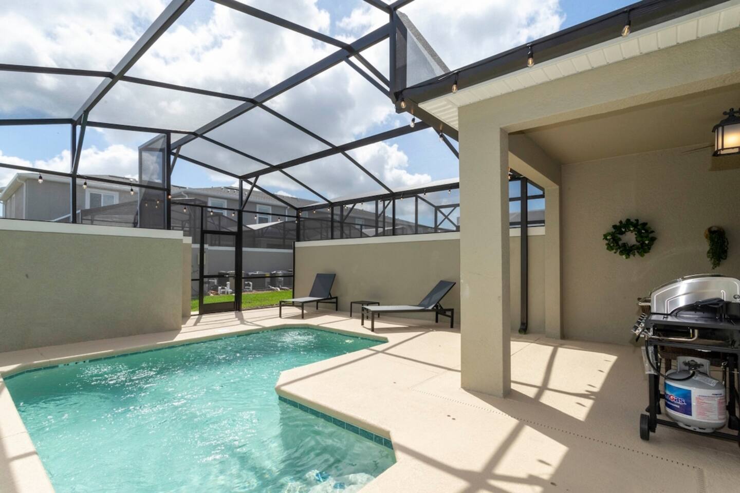 Enjoy a screened private pool with a BBQ grill and comfortable outdoor furniture, perfect for relaxing and dining al fresco.