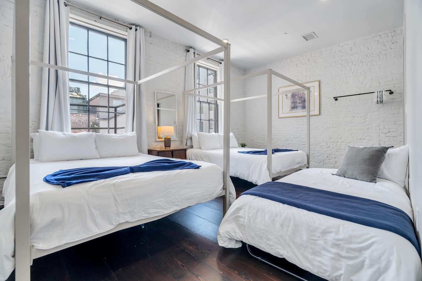Bright and spacious bedroom with double canopy beds—perfect for group stays.