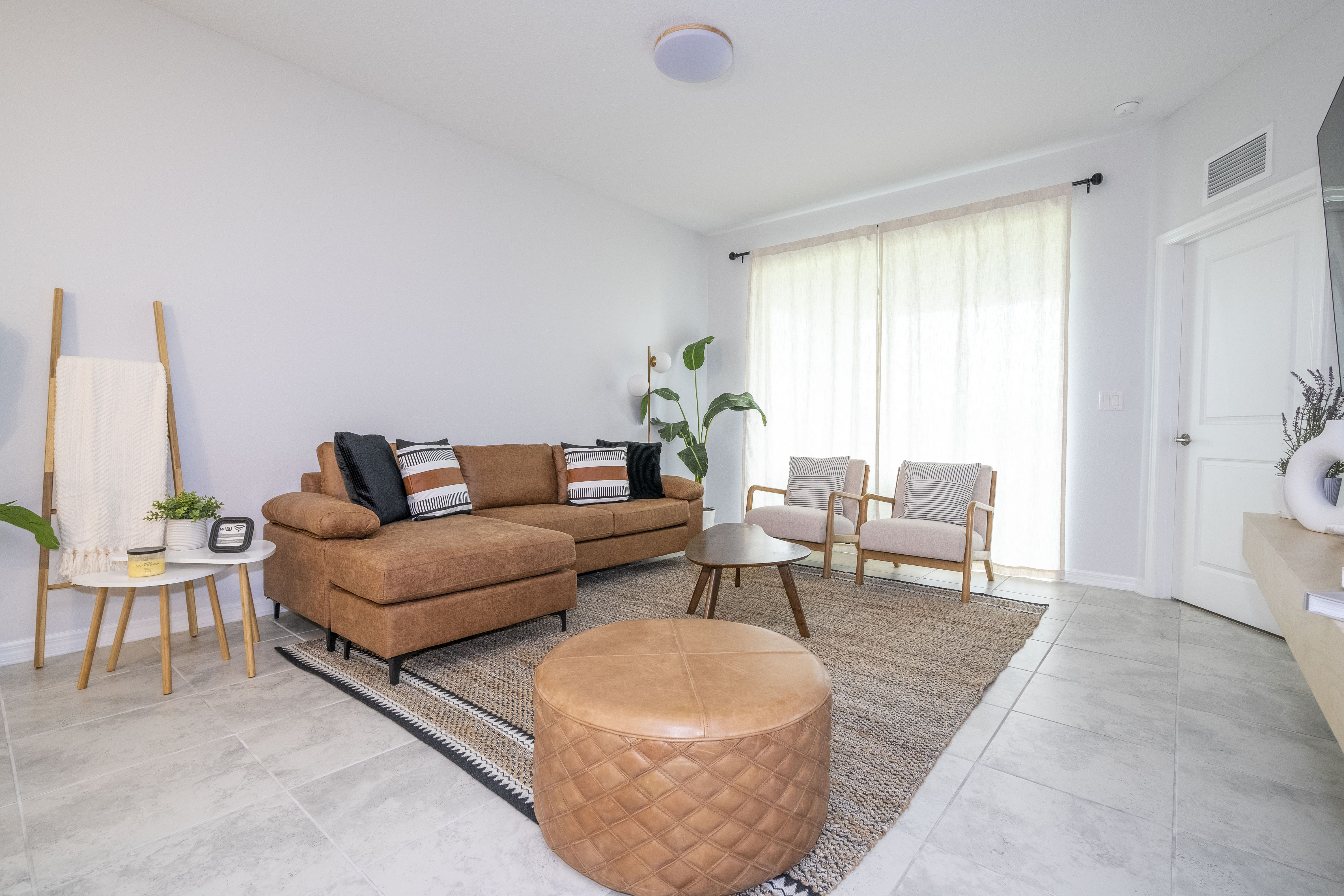Step into this spacious, comfortable living area. The expansive room is adorned with tasteful decor, offering a blend of modern aesthetics and homey warmth. 