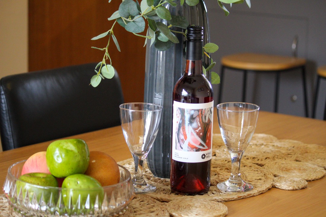 The dining space invites family meals, game nights or shared conversations with sea breeze ambiance. (Wine pictured is for styling purposes only.)