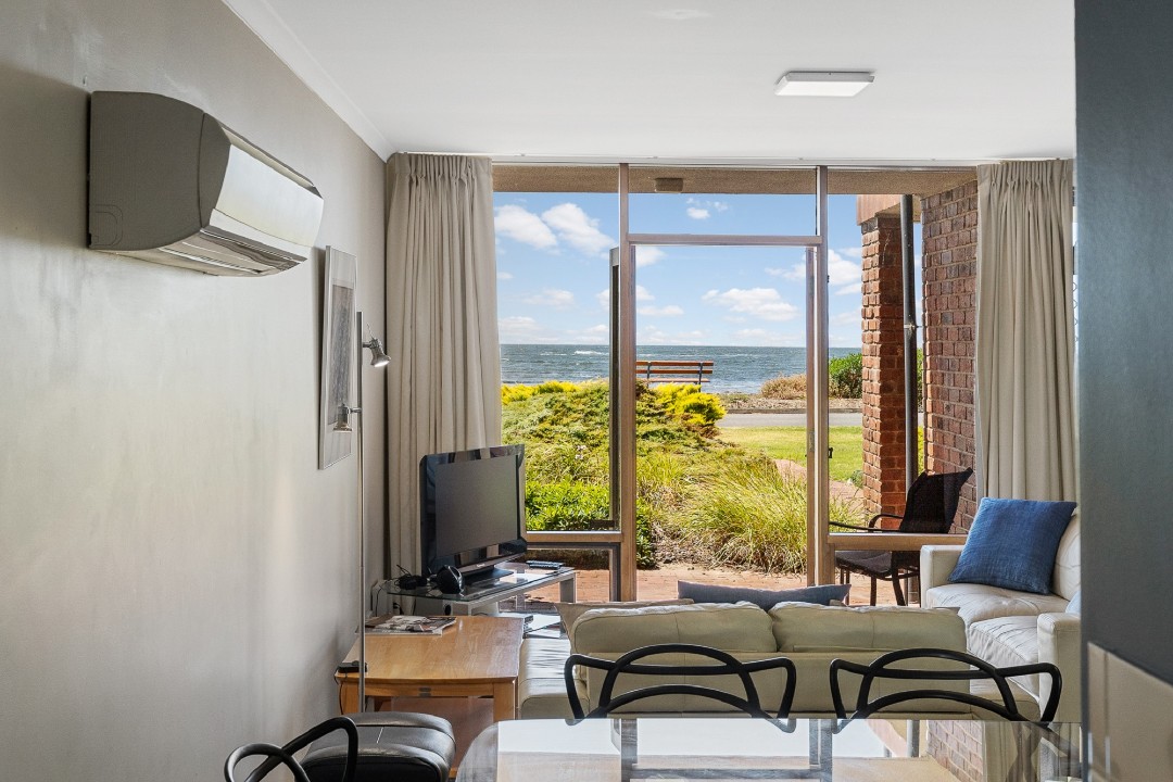 Although the upper-level balcony is not accessible, the apartment features a charming sea-facing patio for enjoying morning coffee or sunset views.