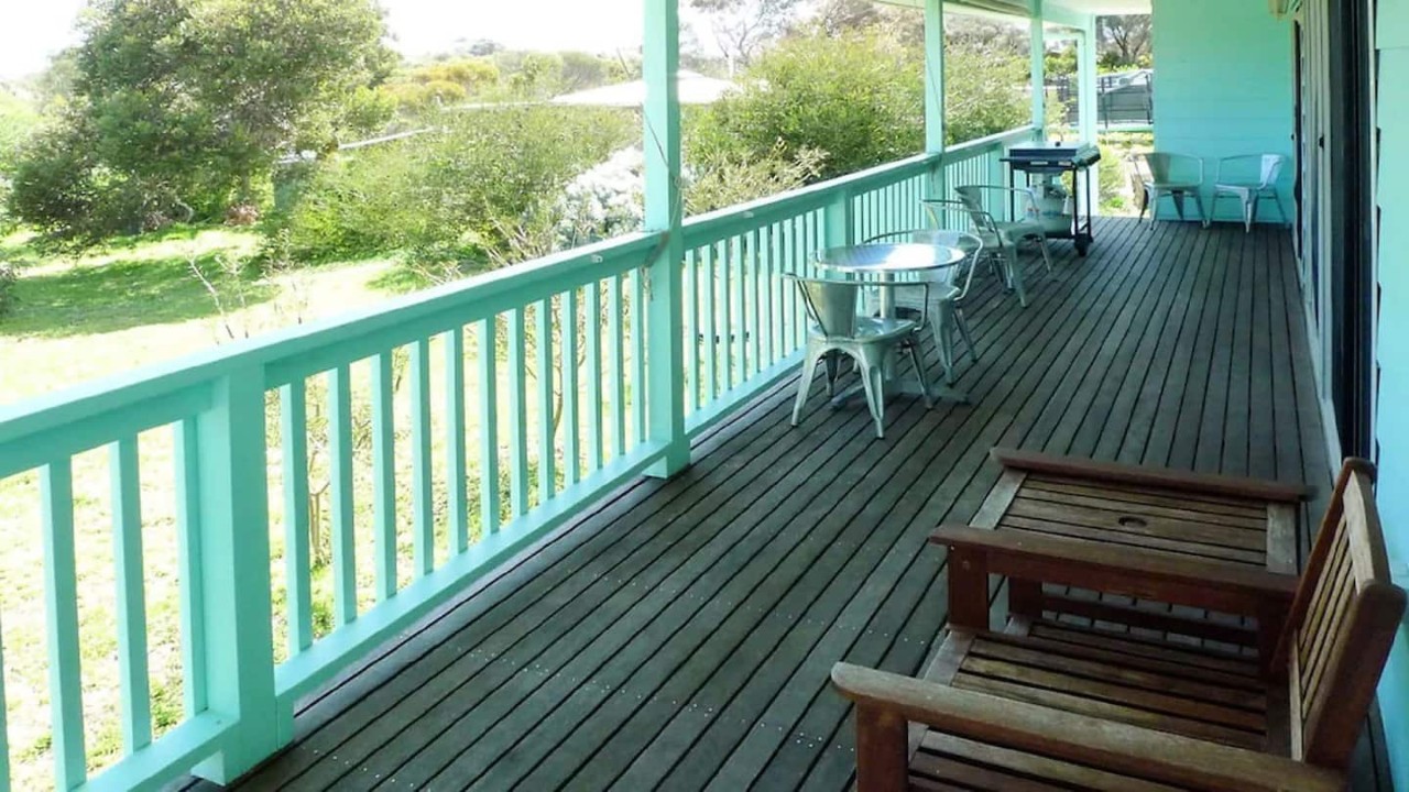 Blue Sea Beach House - Porch with coffee table and chairs, wooden sofa and grill