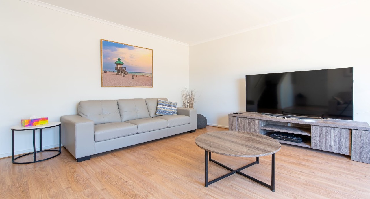 Separate lounge with comfortable sofas and TV, ideal for relaxation and entertainment.