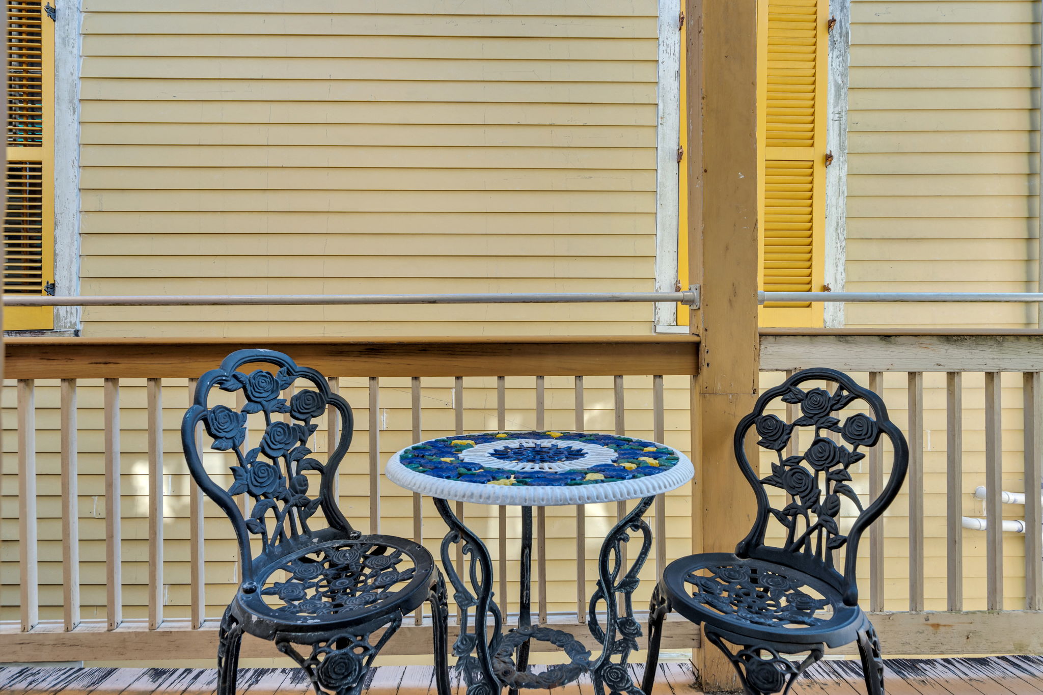 Charming set with mosaic table on sunny balcony, perfect for intimate chats.