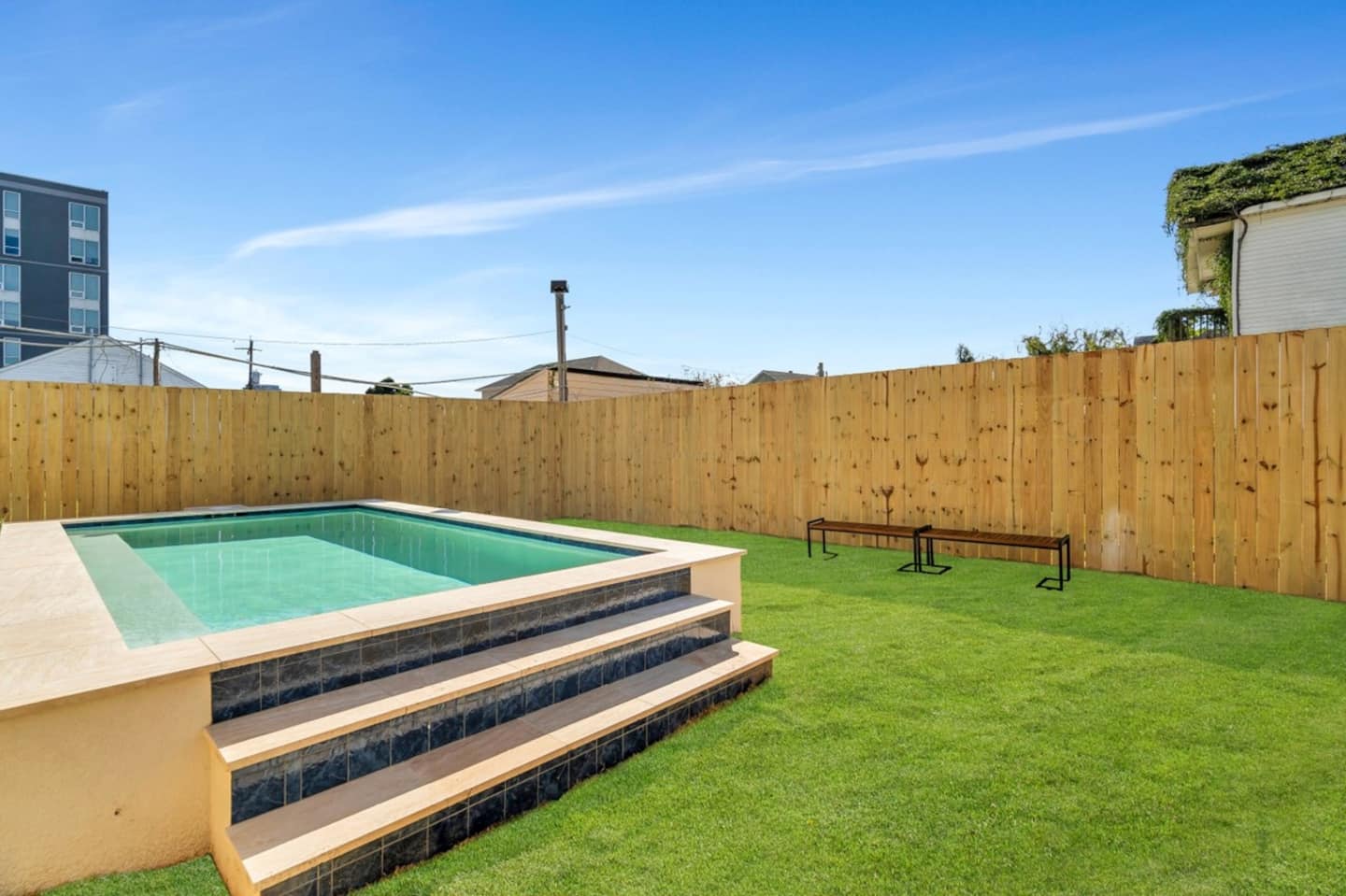 Fully-Fenced Pool with pool toys, towels, and lounge chairs