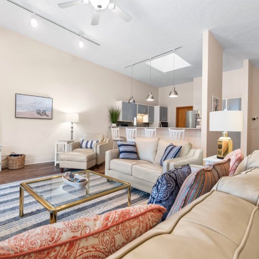 Open living and kitchen under a vaulted ceiling and skylight.