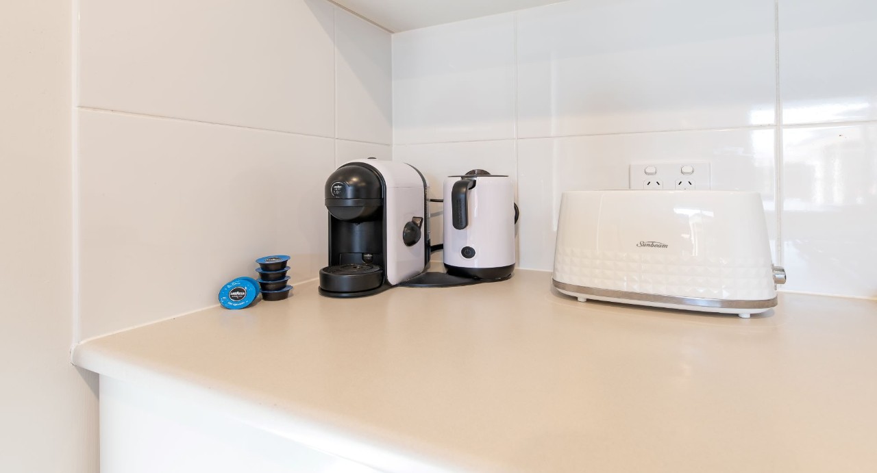 Fully equipped kitchen with Euro gas cooktop, electric oven, rangehood, and built-in dishwasher.