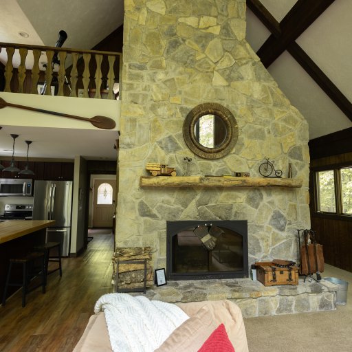 Cozy up by the stone fireplace while staying connected to the fully equipped kitchen—perfect for family gatherings!